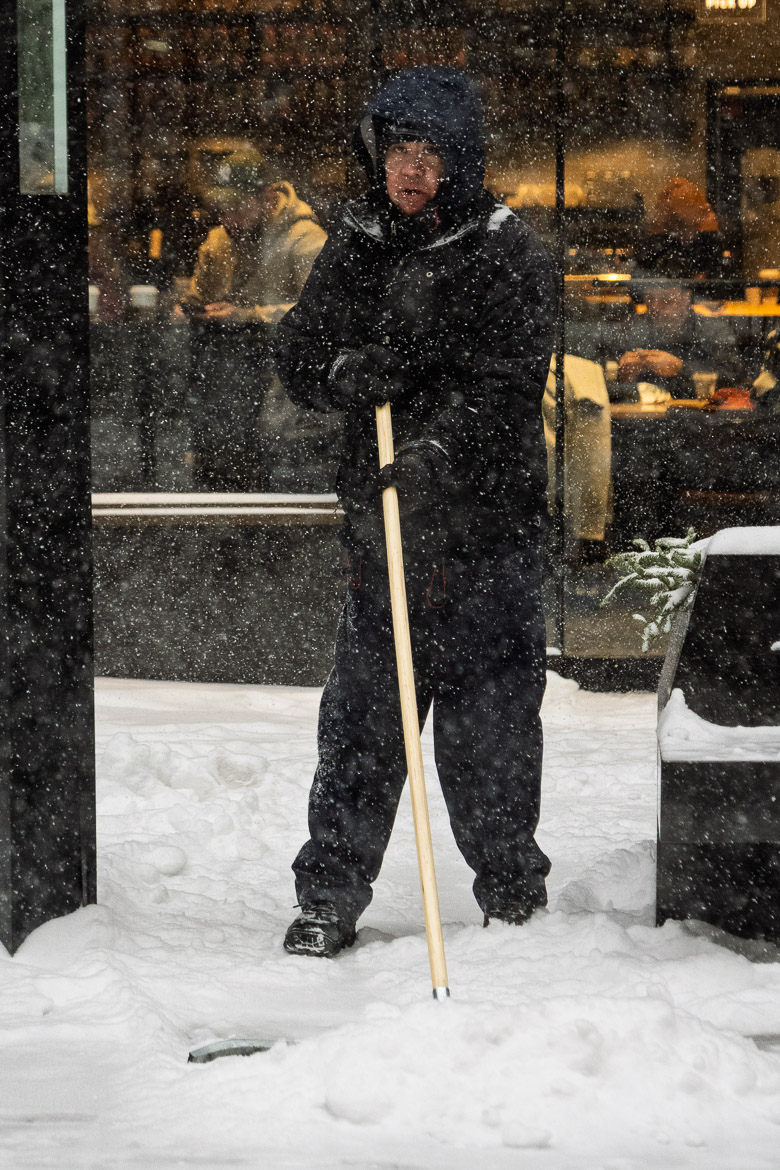 Man using a squeegee to move snow